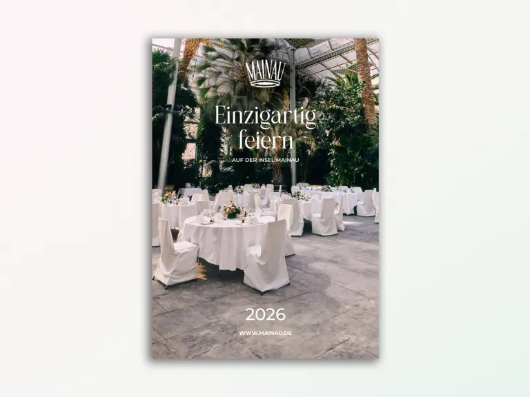 Ansicht der ersten Seite der Bankettmappe. Zu sehen sind gedeckte Tische mit weißen Tischdecken, Geschirr, Gläser und Blumen. Die Tische stehen vor Palmen