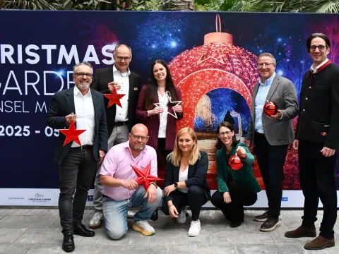 Teilnehmende der Presekonferenz Christmas Garden vor einer Plakatwand der Veranstaltung